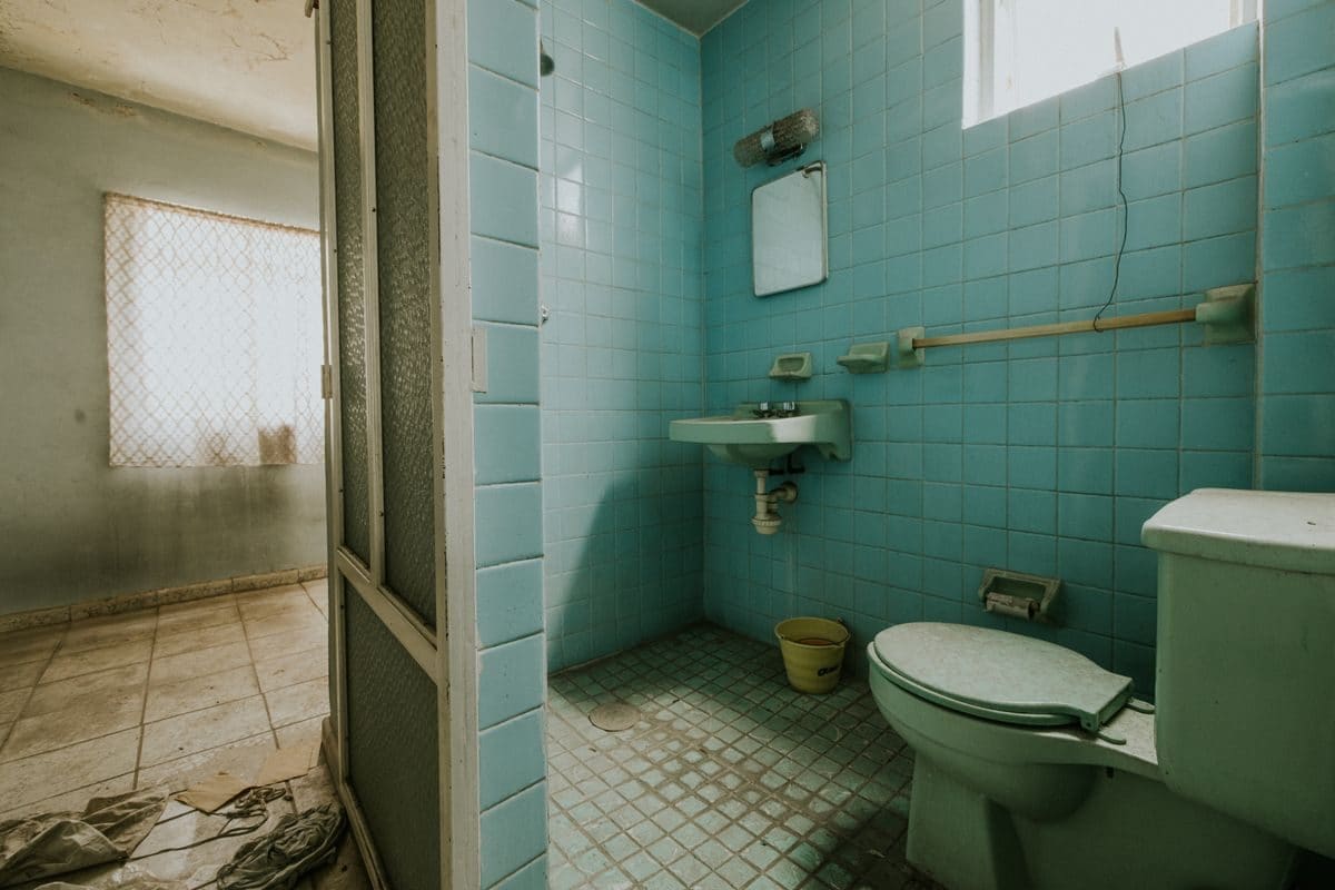 A tired, dated bathroom with old fittings, before renovation
