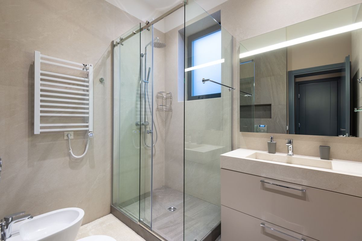 A modern tiled bathroom with a walk-in shower and vanity unit